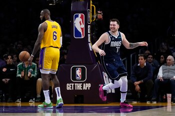 El jugador de los Mavericks de Dallas Luka Doncic (77) sonríe tras encestar una canasta ante LeBron James (6), de los Lakers de Los Ángeles, en la primera mitad del juego de la NBA que enfrentó a ambos equipos, el 12 de enero de 2023, en Los Ángeles. (AP Foto/Jae C. Hong)
