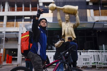 Selfie con la estatua de Marcelo Gallardo, afuera del estadio Monumental en Buenos Aires, el martes 30 de mayo de 2023 (Foto: AP Foto/Iván Fernández)