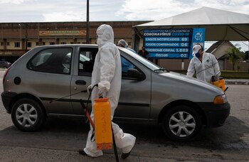 Trabajadores municipales de San Pablo desinfectan vehículos (REUTERS/Roosevelt Cassio)