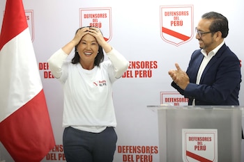 Keiko Fujimori sonríe con manos en la cabeza, vestida de blanco. Un hombre de traje oscuro aplaude. Logos 'Defensores del Perú' y bandera peruana