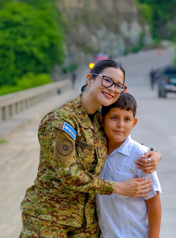 Niñas y niños salvadoreños reciben la visita de la ministra Karla Trigueros en el puente de La Integración, donde se realizó la distribución de materiales escolares (Cortesía Secretaría de Prensa).