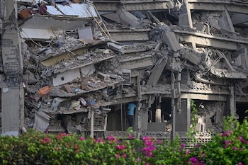 A man inspects a collapsed apartment building following an earthquake in Catia La Mar, La Guaira state, some 30km north-west of Caracas, on June 25, 2026. A twin earthquake that was Venezuela's largest in over a century has killed at least 164 people and destroyed multiple buildings near the capital, where residents searched on June 25 for missing relatives. (Photo by Federico PARRA / AFP)