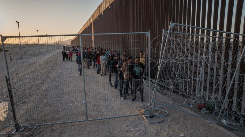 FOTO DE ARCHIVO: Una vista de dron muestra a migrantes mientras se alinean contra el muro fronterizo para entregarse a los funcionarios de inmigración después de romper una valla cargada de alambre de púas a lo largo de la orilla del río Grande en El Paso, Texas, Estados Unidos. 29 de marzo de 2024. REUTERS/Adrees Latif/Archivo