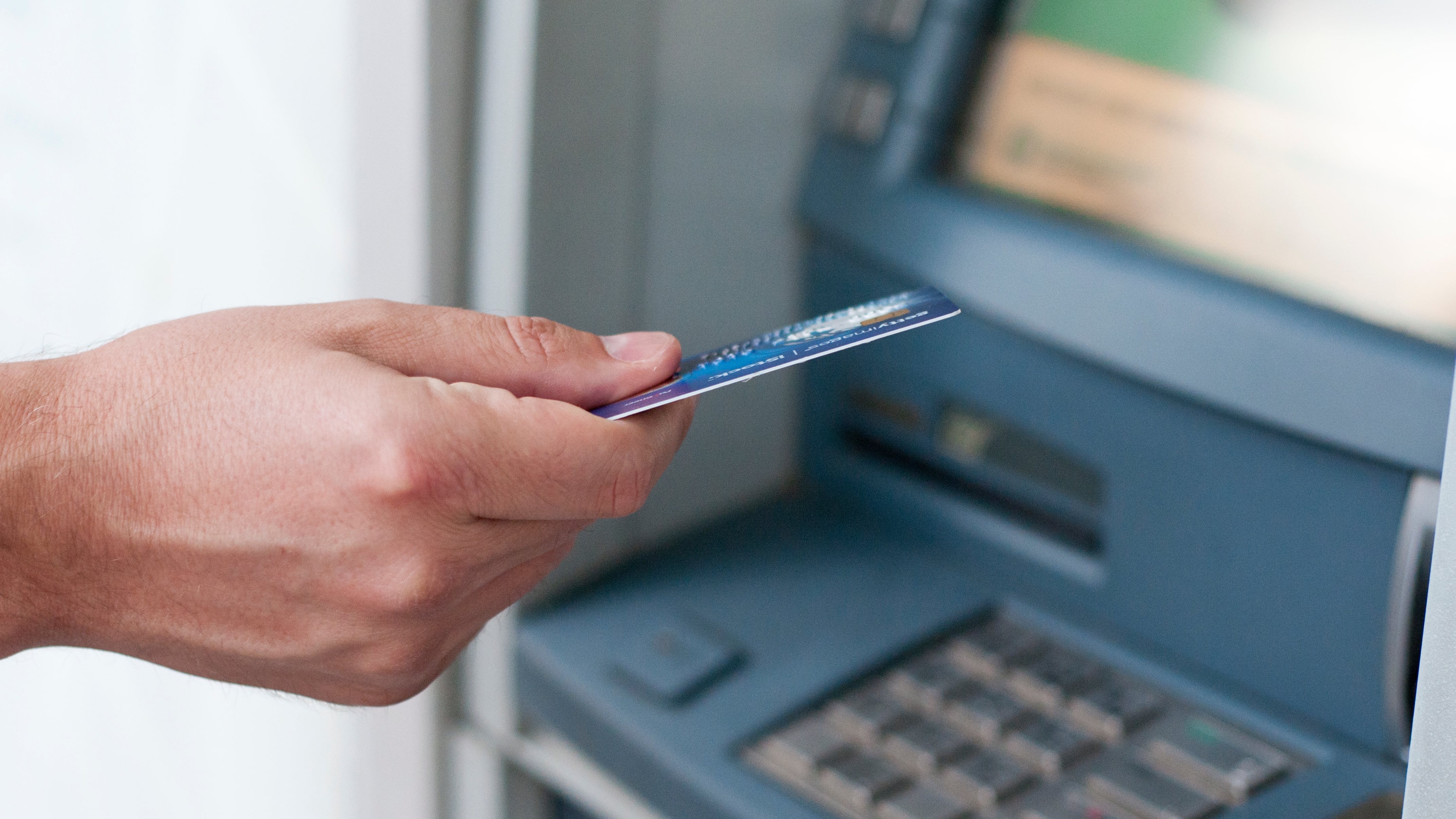 Un hombre inserta la tarjeta en el cajero automático en la máquina de banco (Freepik)