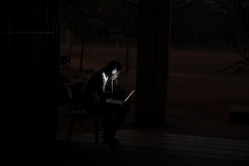 A man studies at night outside the boys building of the Fondation 2iE, an engineering school, during lockdown at the university campus to limit the spread of coronavirus disease (COVID-19), in Ouagadougou, Burkina Faso April 1, 2020. Picture taken April 1, 2020. Reuters/Anne Mimault TPX IMAGES OF THE DAY