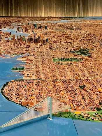 Maqueta a gran escala de la ciudad de Nueva York, con el puente Verrazzano-Narrows en primer plano, rascacielos y zonas residenciales
