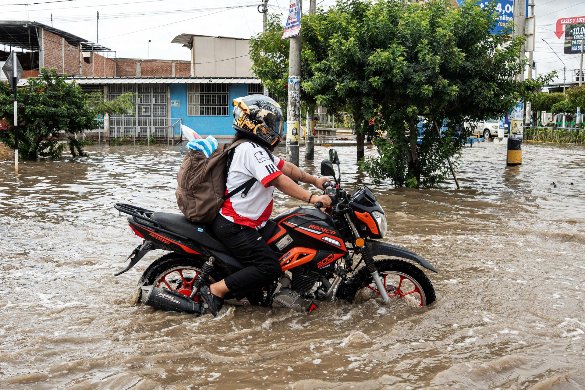 Un motociclista cruza una calle anegada en el distrito Veintiséis de Octubre en Piura tras las lluvias registradas en el norte de Perú. (EFE / Malú Ramahí)