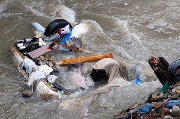 Fotografía que muestra un vehículo arrastrado a una cañada este miércoles, en Las 800, un barrio humilde en Santo Domingo (República Dominicana), que ha sufrido graves inundaciones a causa de las torrenciales lluvias arrojadas por una vaguada que incide sobre gran parte del país. (EFE/Orlando Barría)