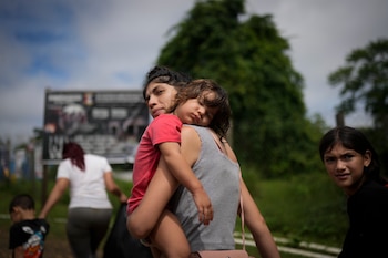 La migrante venezolana Naiber Zerpa sostiene a su hijo Mathías Márquez cuando llegan a un campamento temporal en Lajas Blancas, Panamá (AP Foto/Matías Delacroix/Archivo)