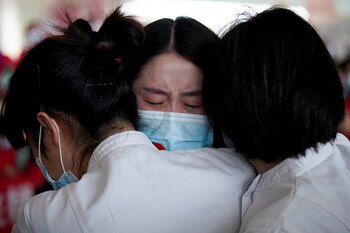 Trabajadores médicos se abrazan en