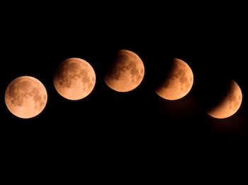 Cinco vistas de la Luna con tonalidad anaranjada muestran distintas fases de un eclipse alineadas de forma horizontal sobre un fondo negro