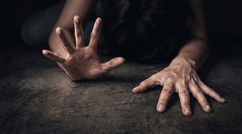 Ilustración de dos manos humanas sobre un suelo oscuro, con una de las palmas extendida hacia el frente en gesto de alto.