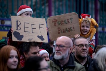 Niños sostienen carteles mientras los