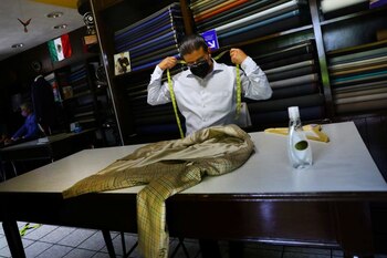 Un sastre mide una chaqueta