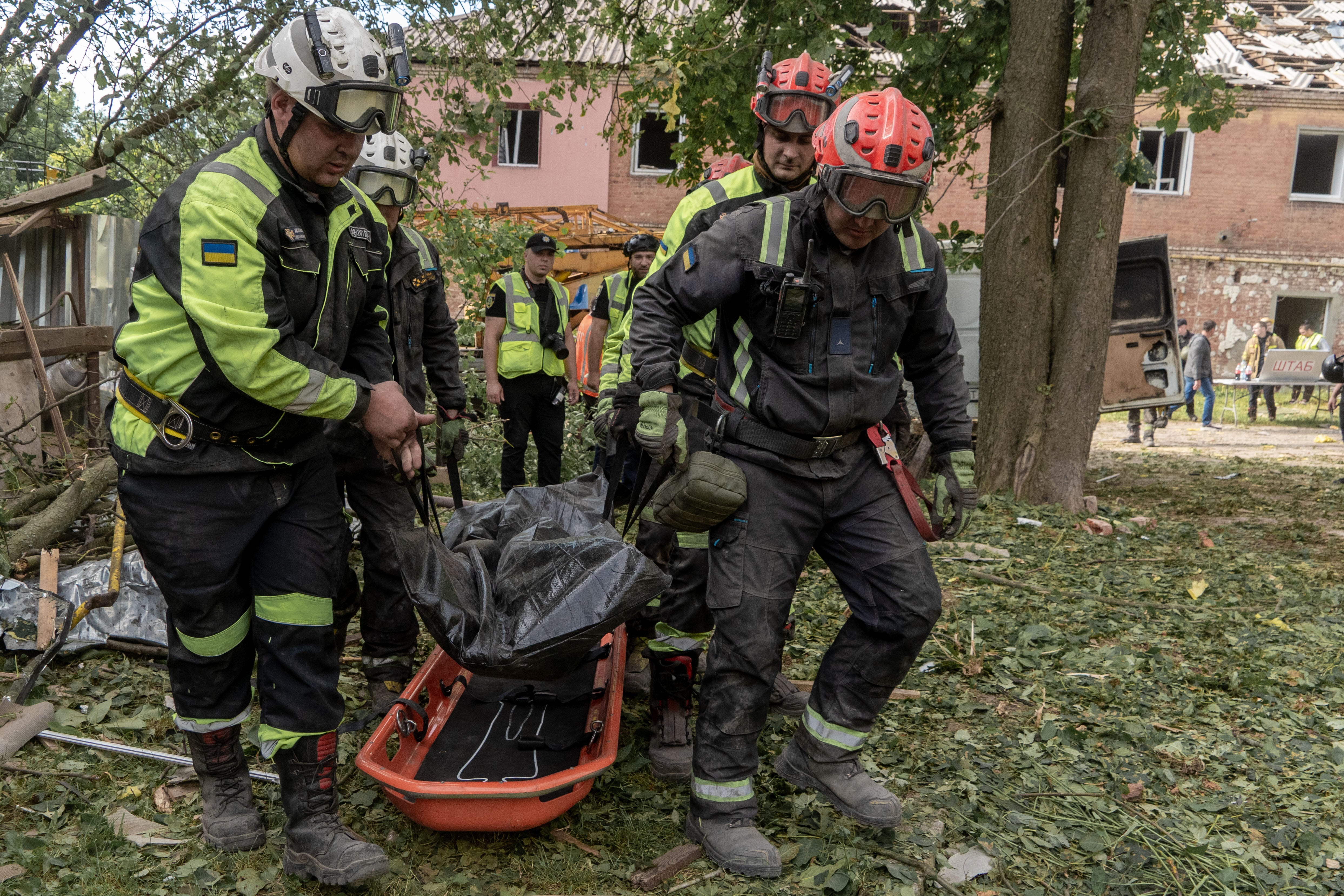 Varios rescatistas trasladan un cuerpo que retiraron de entre los escombros de un edificio de apartamentos tras un ataque ruso con misiles en Kharkiv, Ucrania, el sábado 20 de junio de 2026 (AP Foto/Andrii Marienko)