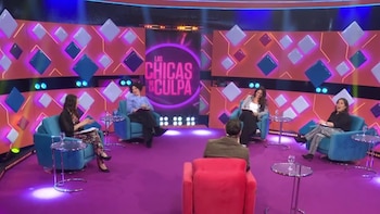 Un hombre de espaldas en butaca roja frente a cuatro mujeres en butacas azules en un plató de TV. Fondo naranja con rombos y logo "Las Chicas de la Culpa"