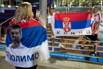 Simpatizantes de Novak Djokovic muestran banderas serbias frente a la Arena Rod Laver de Melbourne, Australia, el viernes 27 de enero de 2023 (AP Foto/Ng Han Guan)