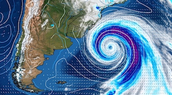 Mapa satelital de Sudamérica y el Océano Atlántico Sur con una gran formación nubosa en espiral, flechas de viento y líneas de presión.