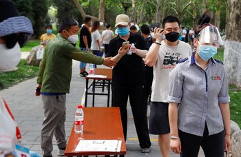 Personas usan mascarillas en Beijing