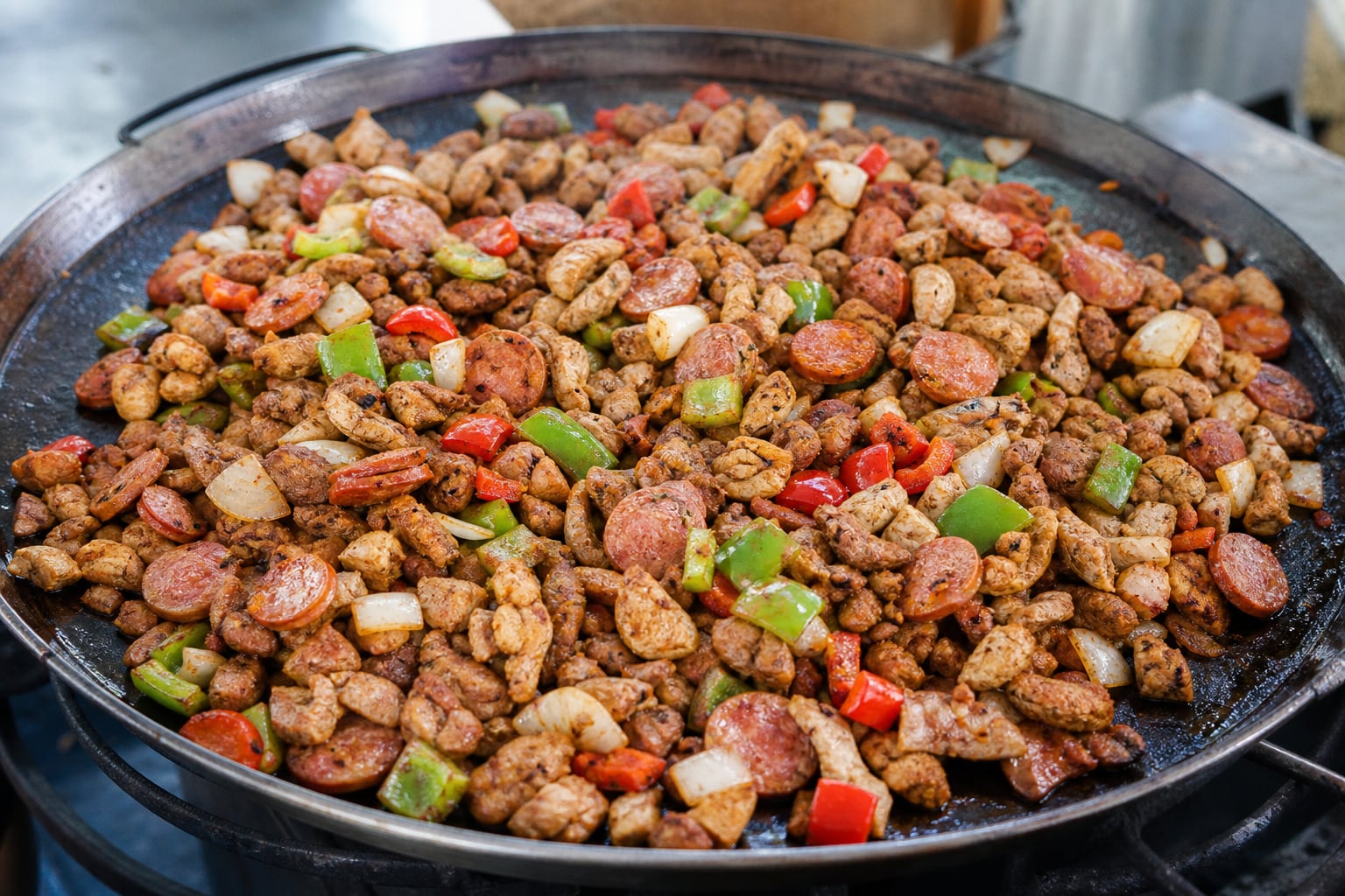 Un disco metálico contiene carne troceada, embutidos, pimientos y cebolla cocinados al estilo de la discada tradicional. (Imagen Ilustrativa Infobae)
