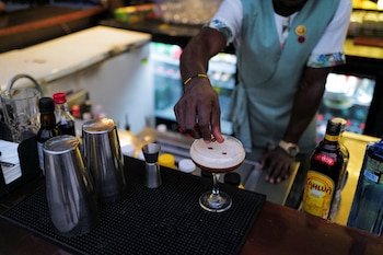 Un coctelero espolvorea granos de café sobre una copa de espresso martini en un bar de Accra, Ghana (REUTERS/Francis Kokoroko)