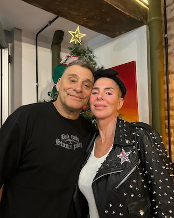 El Turco García y Mariela Prieto sonríen y se abrazan ligeramente frente a un árbol de Navidad decorado con una estrella dorada