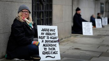 Manifestantes sostienen pancartas frente al