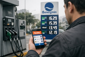 Un hombre sostiene un smartphone con la aplicación Facilito abierta frente a surtidores de combustible y un cartel de precios de Osinergmin en una estación.