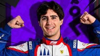 Un joven piloto con casco de carreras, Rafael Camara, sonríe y flexiona ambos brazos, mostrando sus bíceps sobre un fondo morado con líneas diagonales