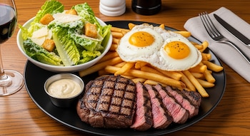 steak frites con papas fritas a caballo y ensalada César
