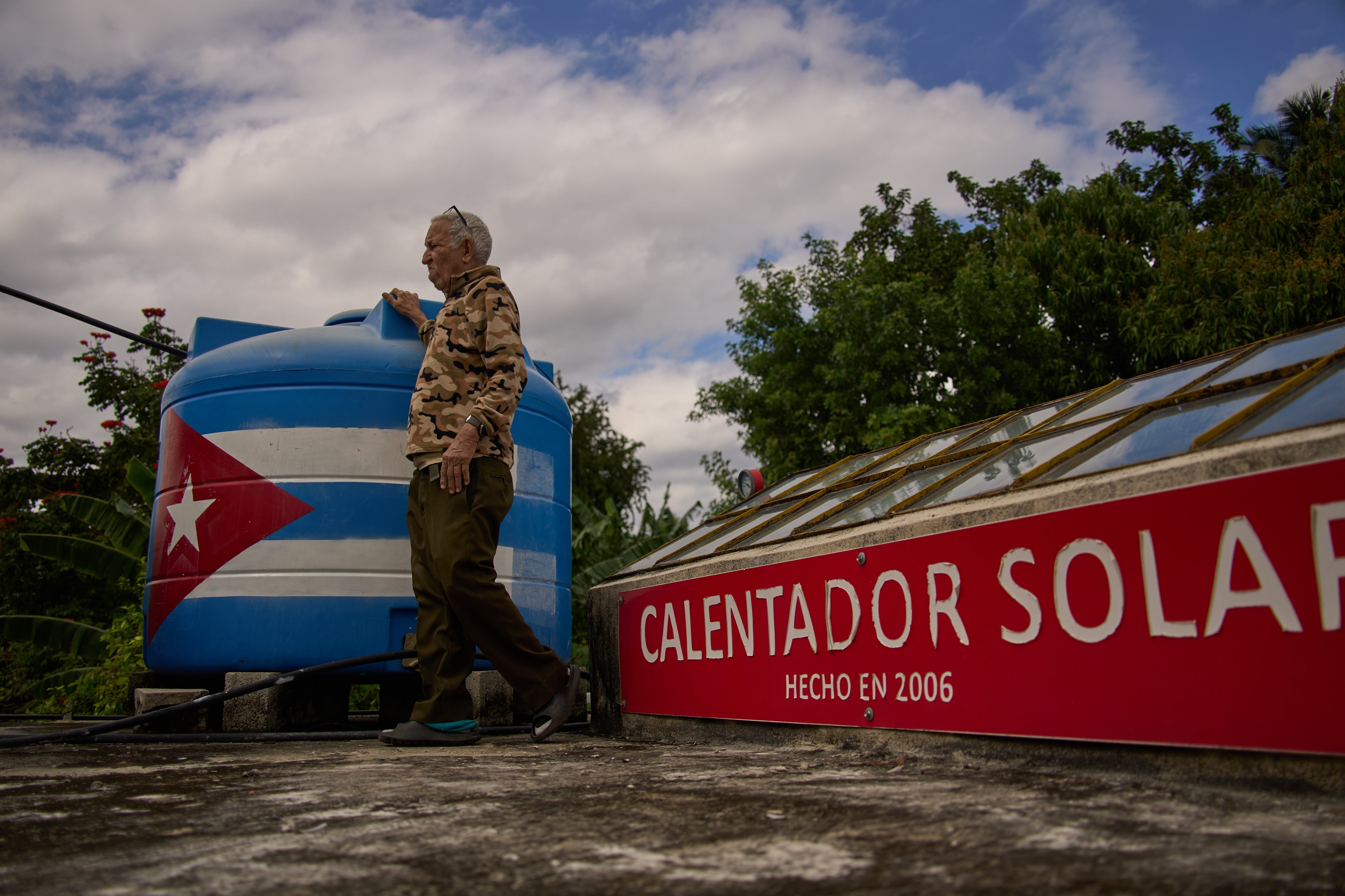 Félix José Morfi observa al horizonte junto a su sistema solar para calentar agua, instalado en el techo de su casa, el jueves 29 de enero de 2026, en Regla, provincia de La Habana (AP Foto/Ramón Espinosa)