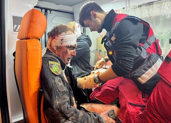 MATERIAL SENSIBLE. ESTA IMAGEN PUEDE OFENDER O PERTURBAR. Un trabajador médico atiende a un policía herido en una ambulancia en el lugar donde se produjo un ataque con misiles rusos, en medio del ataque de Rusia a Ucrania. REUTERS/Vitalii Hnidyi