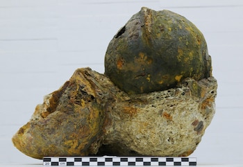 Un casco de hierro oxidado, fragmentado, con restos de pintura y patina. (Universidad de Alicante)