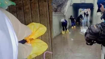Un vendedor improvisado ofrece bolsas a peatones para cruzar un bypass inundado en Lima