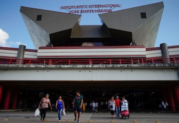 Vista frontal del Aeropuerto Internacional José Martí de La Habana con su estructura geométrica. Debajo, varias personas caminan por la zona de acceso
