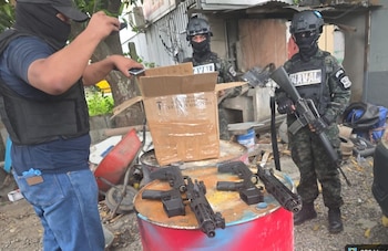 Agentes de las Fuerzas Armadas y la ATIC inspeccionaron una encomienda durante el operativo en San Pedro Sula. Dos fusiles AR-15 fueron decomisados como parte de la evidencia asegurada por las autoridades. (Foto: Fuerzas Armadas)