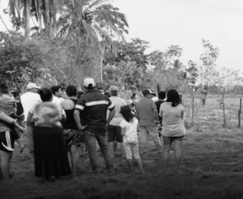 Familiares y residentes se reúnen cerca del lugar donde fueron hallados los cuerpos tras el ataque a balazos./(Emisoras Unidas)