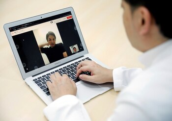 FILE PHOTO: Medical doctor Makoto Kitada demonstrates a telemedicine application service called 'CLINICS', developed by Japanese medical start-up Medley Inc., in Tokyo, Japan, July 8, 2020. Picture taken July 8, 2020. REUTERS/Issei Kato/File Photo