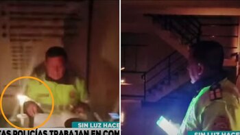 Policía alumbra con su celular para poder atender a un ciudadano.