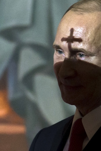 La mitra del patriarca Kirill proyecta una sombra sobre el rostro de Putin durante un servicio de Pascua ortodoxa en la Catedral de Cristo Salvador, en medio del rol de la Iglesia en los valores conservadores que promueve el Kremlin, en Moscú, el 12 de abril de 2015. (REUTERS/Ivan Sekretarev/Pool)