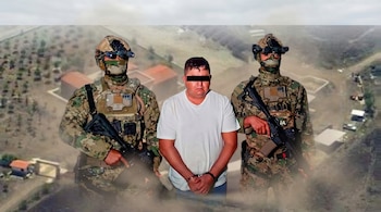 Hombre esposado con camiseta blanca, flanqueado por dos marinos armados en uniforme de camuflaje, sobrepuesto en una vista aérea de un rancho rural.