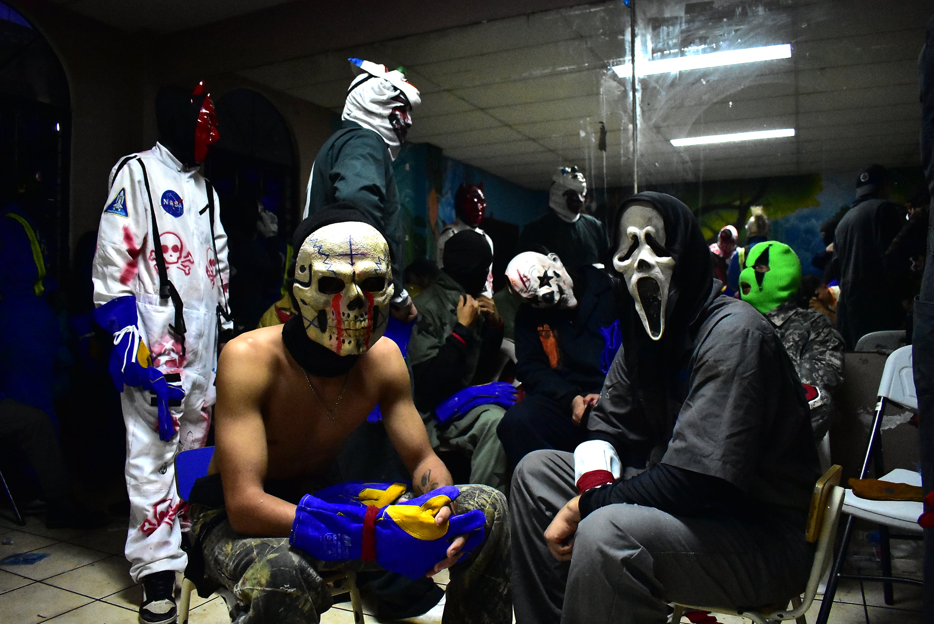 Previo al combate en Nejapa, los jóvenes participantes se alistan en un salón municipal, donde se ponen su traje temático y, la mayoría, con máscaras alusivos a algún personaje de terror. (Infobae Centroamérica/Emerson Del Cid)