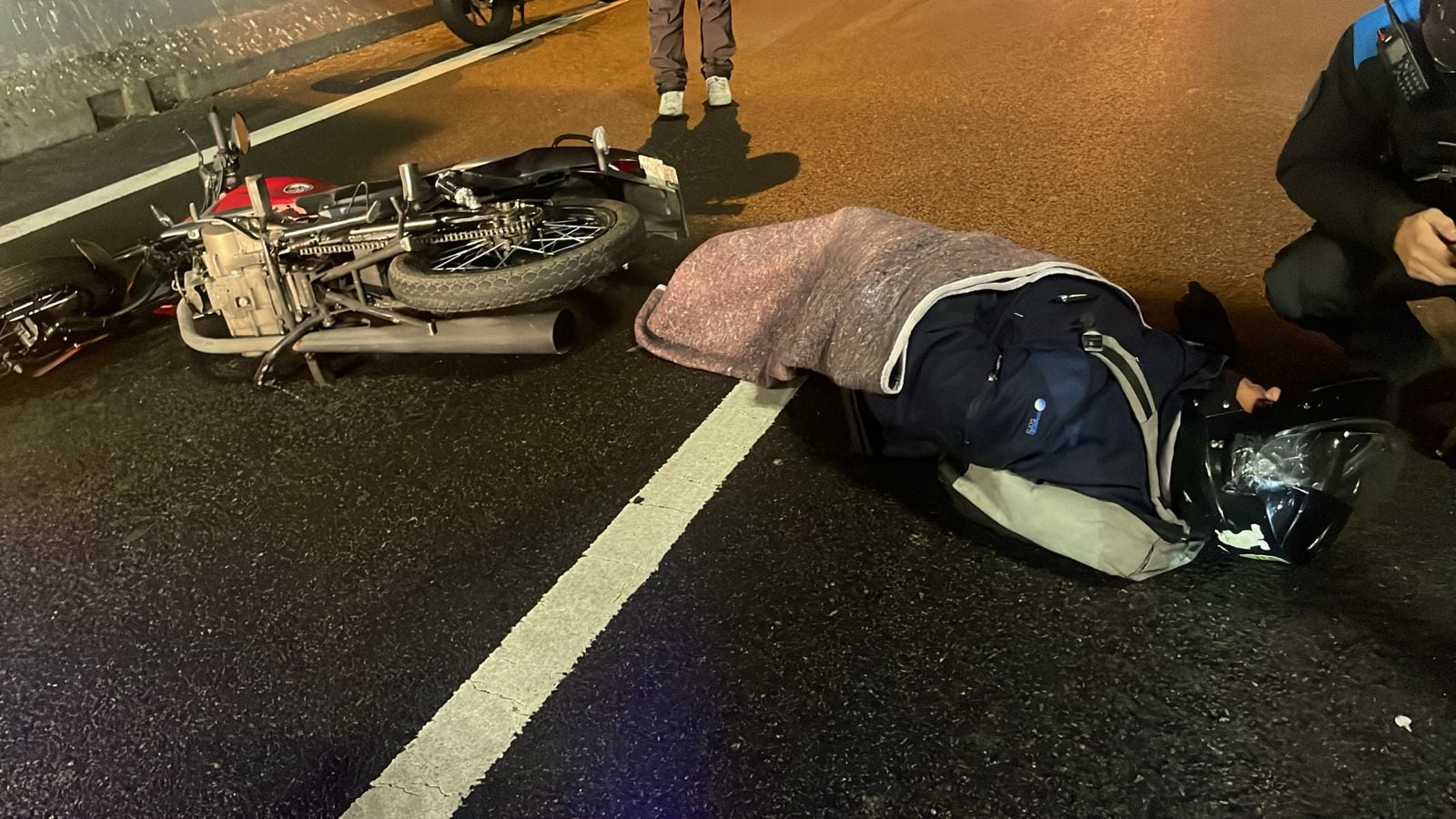 La policía asiste a uno de los motociclistas heridos mientras espera la llegada de la ambulancia del SAME