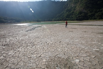 At the lagoon of Alegría, Usulután, El Salvador, water levels have dropped dramatically in the drought that is affecting the region. Here, the water has receded hundreds of metres, a man carries a 'cantaro' of water across the dry lagoon bed. The effect of climate changes in the central american region are already extreme.