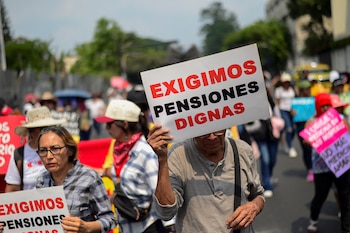 Un hombre sostiene un cartel