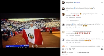 Un tenista joven vestido de blanco en una cancha de arcilla sostiene la bandera peruana ante un estadio lleno, con el logo de Tennis TV y marcador visible en pantalla