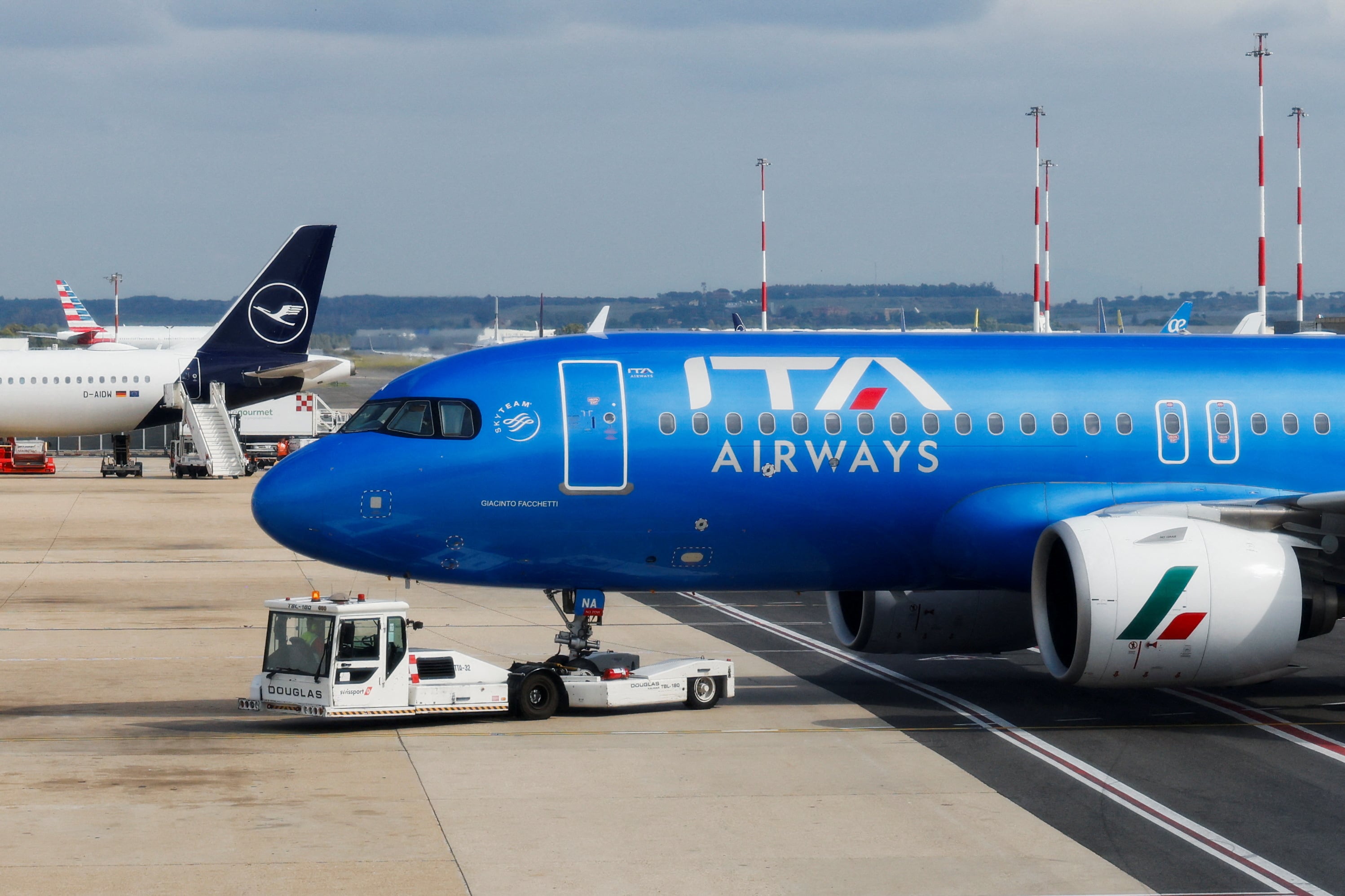 Un avión de la aerolínea italiana Italia Trasporto Aereo (ITA Airways) estaciona junto a un avión de Lufthansa en el Aeropuerto Internacional Leonardo da Vinci en Fiumicino, cerca de Roma, Italia (REUTERS/Remo Casilli/Archivo)