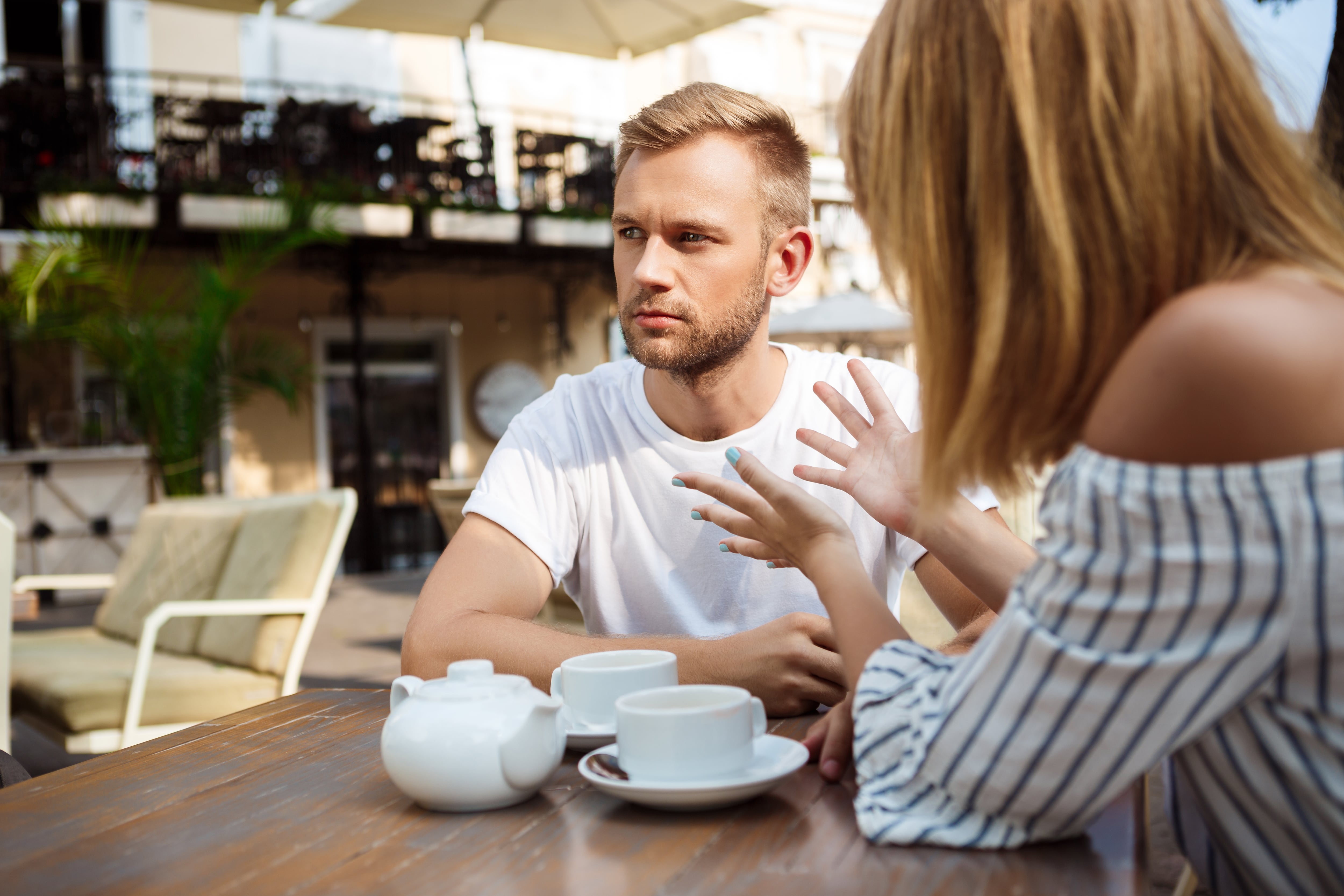 Una pareja discutiendo en la terraza de un bar (Freepik)