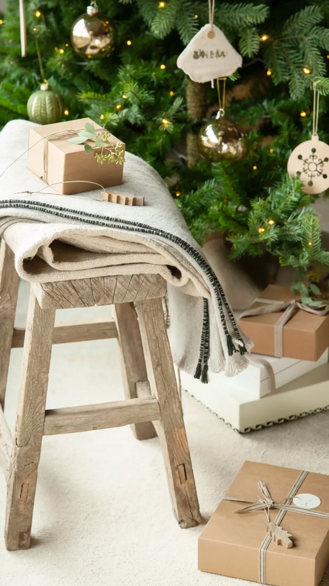 Regalos envueltos en papel madera adornados con cordones de yute y hojas secas refuerzan la estética natural y sostenible en Navidad