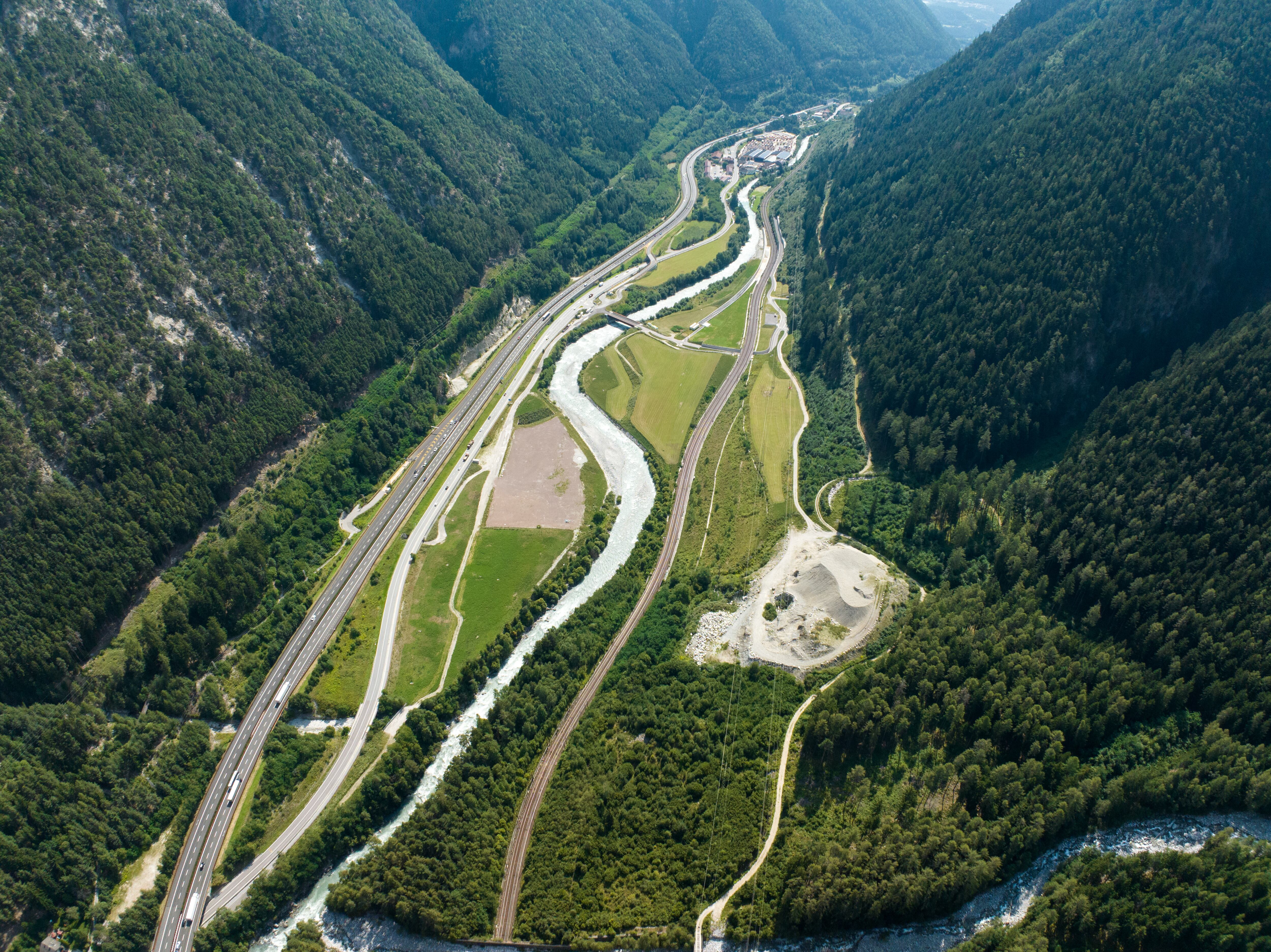 La compleja infraestructura de carreteras, ferrocarriles y el río Inn serpentea por el valle alpino, enmarcando las obras del Túnel de Base del Brenner, un proyecto clave para Europa(© BBT SE)